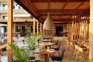 a restaurant with wooden tables and chairs in a building at The Syntopia Hotel - Adults Only in Adelianos Kampos