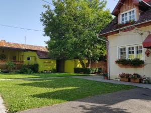ハツェグにあるPensiunea Buneaの庭木のある黄色い家