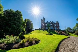 an old castle on top of a grassy hill at Sherbrooke Castle Hotel in Glasgow
