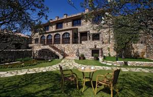 uma casa de pedra com uma mesa e cadeiras no quintal em Hotel Rural & Spa Los Ánades em Abánades