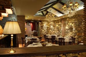 a restaurant with tables and chairs and a chandelier at Hotel Rural & Spa Los Ánades in Abánades