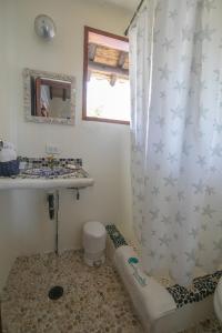 a bathroom with a shower curtain with a toilet and a sink at Sal Si Puedes in Tintipan Island