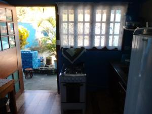 a kitchen with a stove and a window at Chalé da Dô in Ilhabela