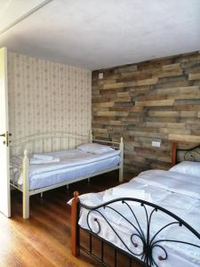 a bedroom with two beds and a wooden wall at Sakhli Laghamshi in Mestia