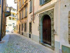 eine Gasse mit einer braunen Tür an der Seite eines Gebäudes in der Unterkunft San Lorenzo Cozy Studio in Bergamo