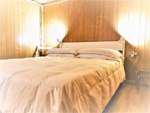 - une chambre avec un grand lit blanc et des murs en bois dans l'établissement San Lorenzo Cozy Studio, à Bergame