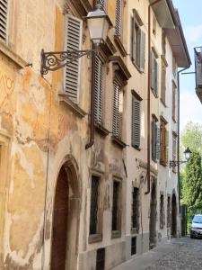 ein altes Gebäude mit einem Bogen in einer Straße in der Unterkunft San Lorenzo Cozy Studio in Bergamo