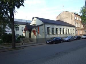 un grupo de coches estacionados frente a un edificio en Leo, en Daugavpils