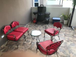 - un salon avec des chaises rouges et une table dans l'établissement Aprtamento Deluxe Santiago, Residencial Palma Real R402, à Santiago de los Caballeros