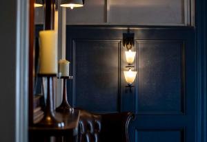 a room with a wall with two lights and a chair at Dunstan House in Burnham on Sea