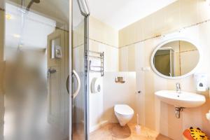 a bathroom with a shower and a toilet and a sink at Nakvynė pas Romą in Nida +98 photos