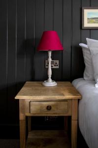 a table with a lamp on it next to a bed at Dunstan House in Burnham on Sea
