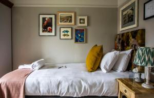 a bedroom with a large white bed with pictures on the wall at Dunstan House in Burnham on Sea