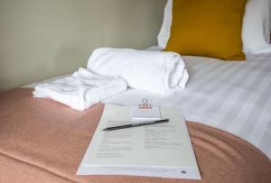 a hotel room with towels and a sign on a bed at Dunstan House in Burnham on Sea