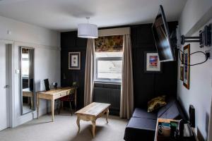a living room with a blue couch and a table at Dunstan House in Burnham on Sea
