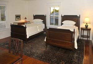 1 dormitorio con 2 camas y alfombra en Walnut Run Farm, en Woodville