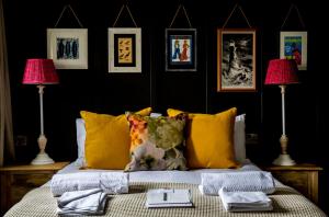 a bedroom with a bed with yellow pillows and two lamps at Dunstan House in Burnham on Sea