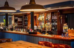 a bar in a restaurant with a wooden table and chairs at Dunstan House in Burnham on Sea