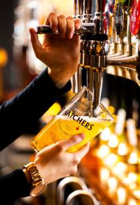 a person is holding a cell phone and a drink at Dunstan House in Burnham on Sea