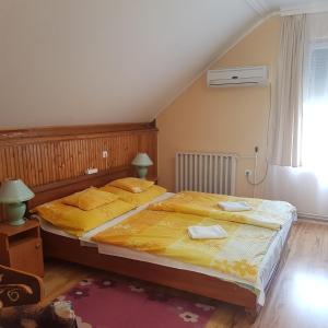 ハイドゥソボスローにあるMuskátli Apartman 2.のベッドルーム1室(大型ベッド1台、黄色いシーツ付)