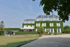 Una casa grande con hiedra verde. en Château de Sancy, en Sancy-lès-Meaux