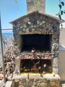 a stone oven with a pile of logs in it at Sea View Bungalows in Skala Kallirachis