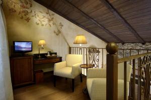 Habitación con balcón con TV y sillas. en Hotel Rural & Spa Los Ánades, en Abánades