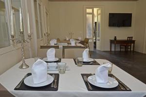 uma mesa de jantar com uma toalha de mesa branca e guardanapos em Regia Trazzera em Ragusa