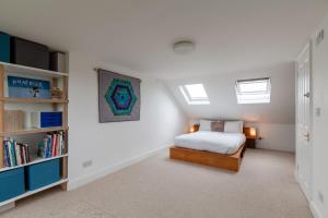 a bedroom with a bed and a book shelf at Veeve - Duckett's Green Charm in London