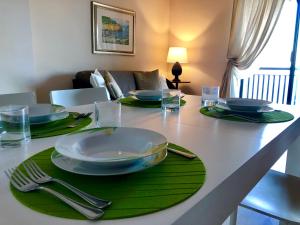 a dining room table with plates and utensils on it at Taliari Taormina Apartment in Taormina
