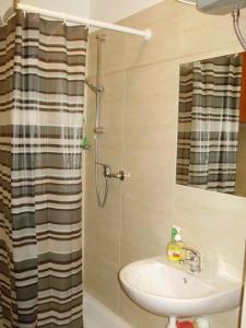 een badkamer met een wastafel en een douche met een spiegel bij Dom wakacyjny bezpośrednio przy Jeziorze Białym in Okuninka