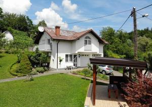 a white house with a garden in front of it at Apartmani Hršak in Krapina