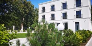 a white building with trees in front of it at FOREST PALANGA RESORT in Palanga