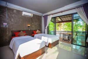 a bedroom with two beds and a balcony at BR2 House Resort in Phayao