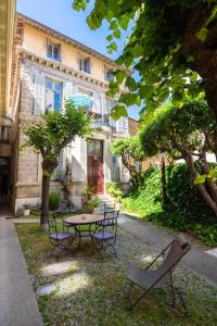 un patio con mesa y sillas frente a un edificio en La Maïoun Guesthouse en Niza