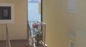 a stairway with a plant in a metal cage at APARTMENT NUNA in Baška +14 photos