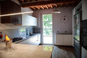 a kitchen with a counter and a clock on the wall at Tipical Tuscany Apartment near Lucca! in Capannori