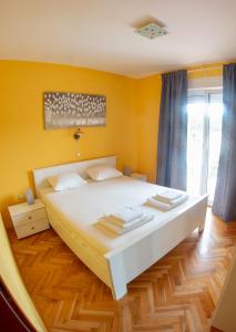 a bedroom with a large white bed in a room at Apartments Neda in Kampor
