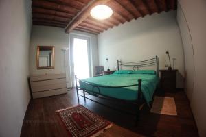 a bedroom with a green bed and a window at Tipical Tuscany House near Lucca! in Capannori
