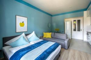 1 dormitorio con paredes azules, 1 cama y 1 sofá en Ruterra Apartments by Cathedral en Praga