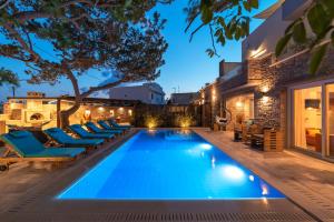 una casa y una piscina infinita con tumbonas en Paradisos luxury villas next to beach, en Koutsourás