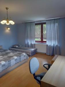a bedroom with two beds and a chair and a window at DreamLand in Poprad