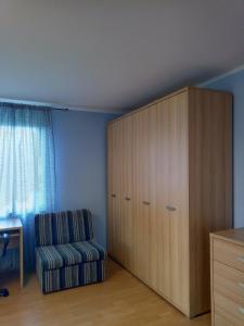 a bedroom with a large wooden cabinet and a chair at DreamLand in Poprad