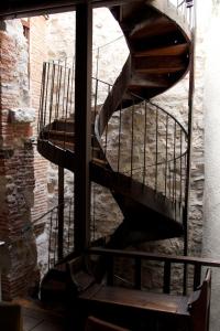 a spiral staircase in a building with a stone wall at Chambre cozy et Salon de 60 m2 au coeur de la cité in Cordes-sur-Ciel
