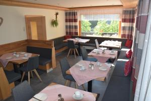 ein Restaurant mit Tischen und Stühlen und einem Fenster in der Unterkunft Pension Appartement Ambrosi in Heiligenblut