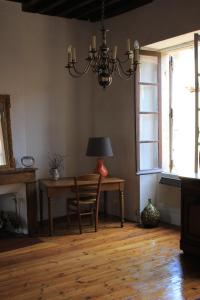 Un comedor con una mesa y una lámpara de araña. en Chambre cozy et Salon de 60 m2 au coeur de la cité, en Cordes-sur-Ciel