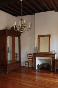 un soggiorno con specchio e lampadario pendente di Chambre cozy et Salon de 60 m2 au coeur de la cité a Cordes-sur-Ciel
