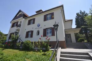 a white building with brown windows and stairs at Republique in Sibiu