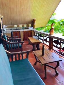 a porch with chairs and a table and a counter at Cabinas Jimenez in Puerto Jiménez