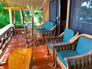 eine abgeschirmte Veranda mit Stühlen und einem Tisch in der Unterkunft Cabinas Jimenez in Puerto Jiménez